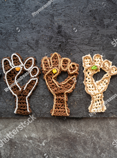 3 hands of different shades: black, brown, white